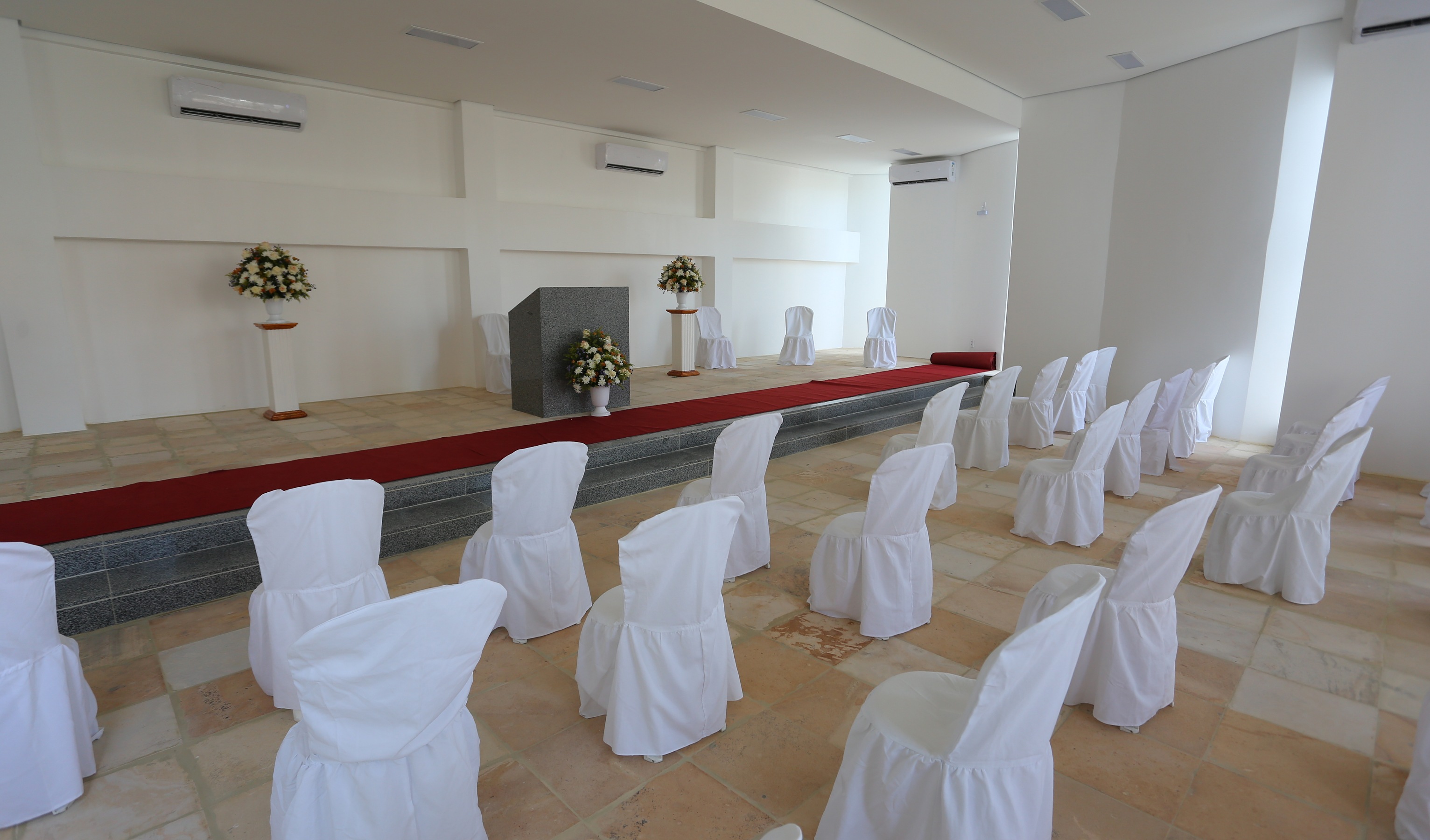 centro ecumênico vazio com altar com flores e cadeiras em frente